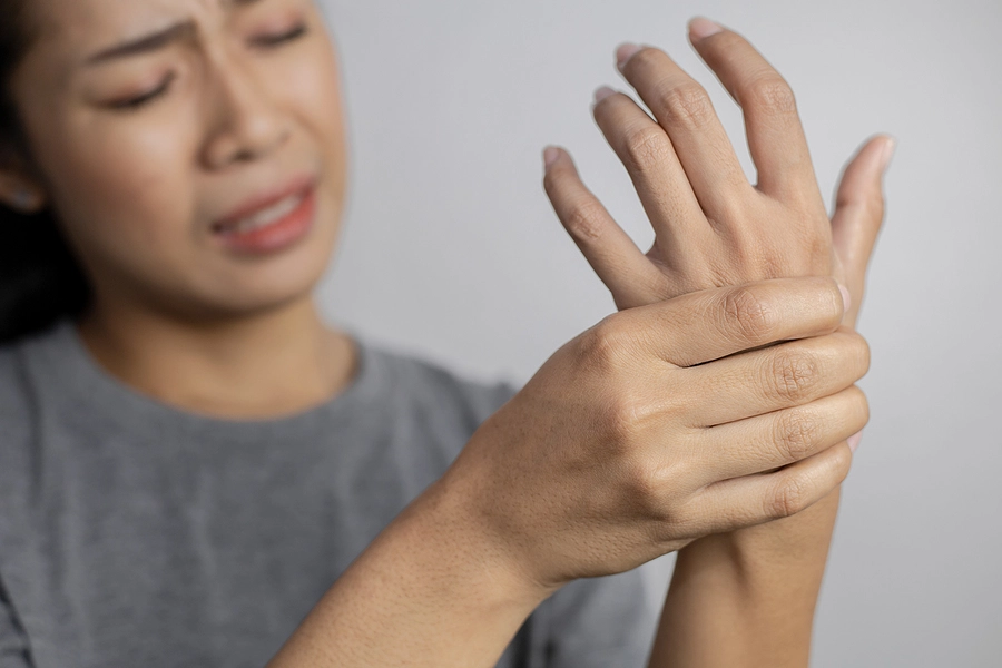 woman holding wrist in pain after sustaining an injury in a briarwood car accident